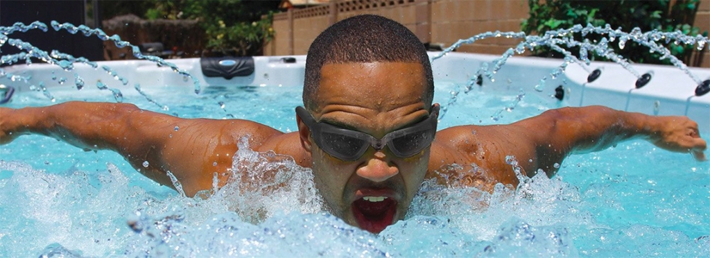 man swimming in swim spa denver