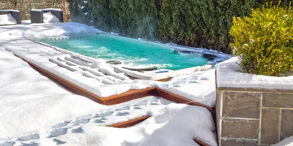 swim spa with foot prints in snow surrounding spa