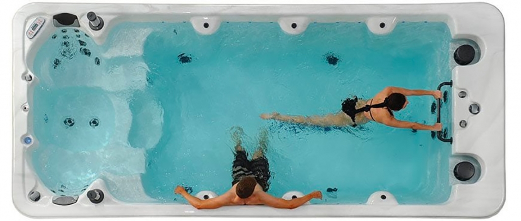 Woman swimming in a swim spa in Denver with man relaxing in swim spa