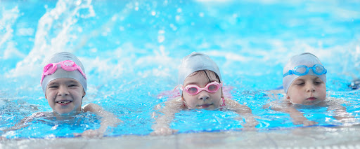 three kids swimming in a swim spa